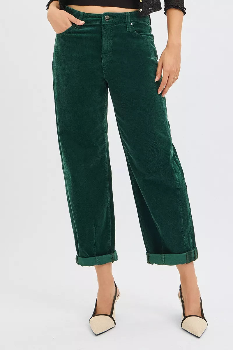 Person wearing green barrel corduroy pants on a white background