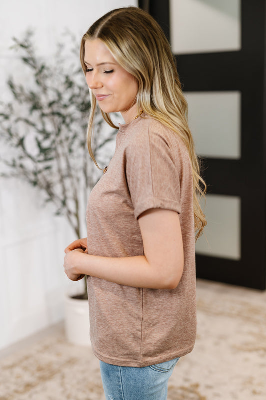 Woman wearing a brown t-shirt in an indoor setting