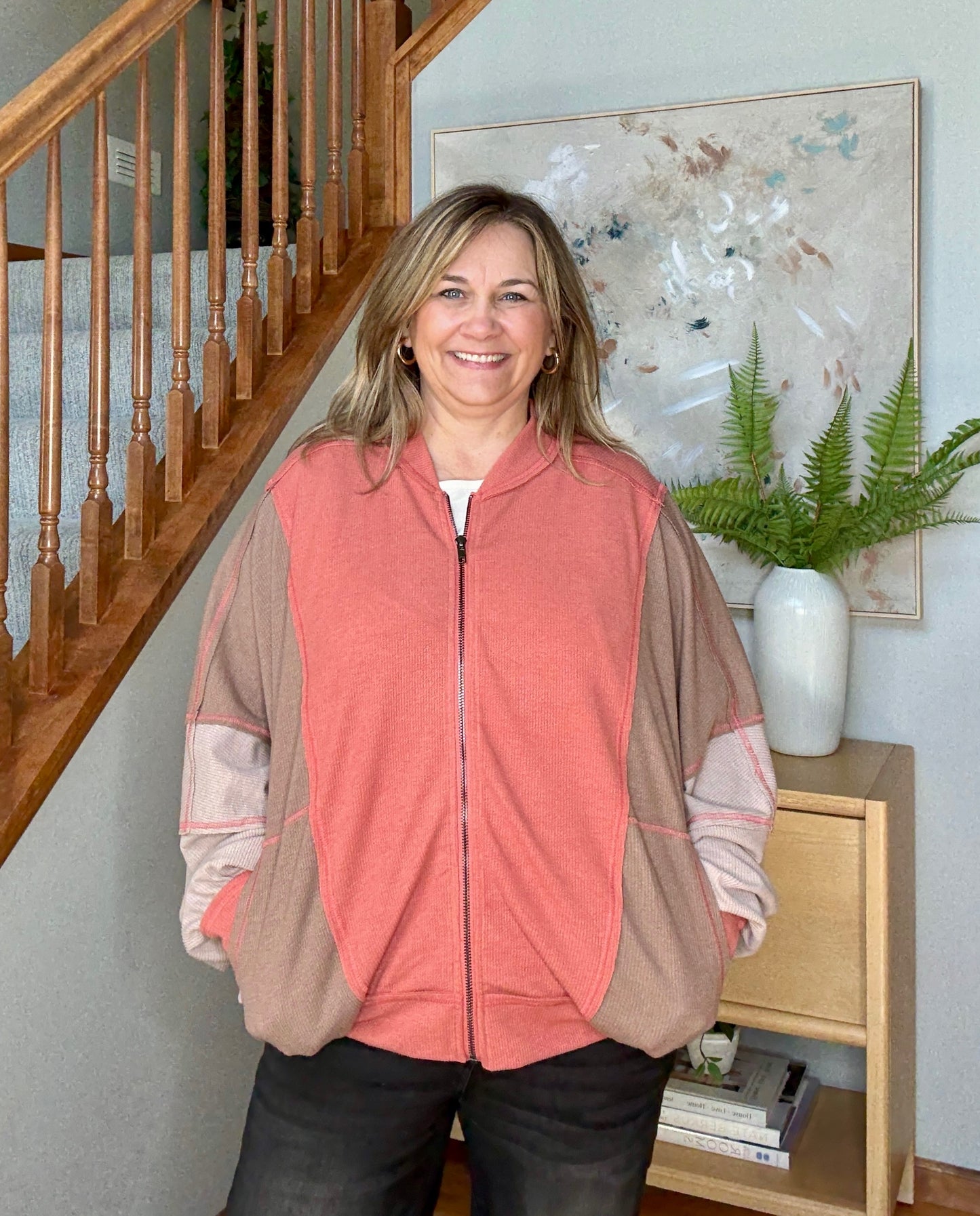 Woman standing in a colorblock dolman sleeve full zip
