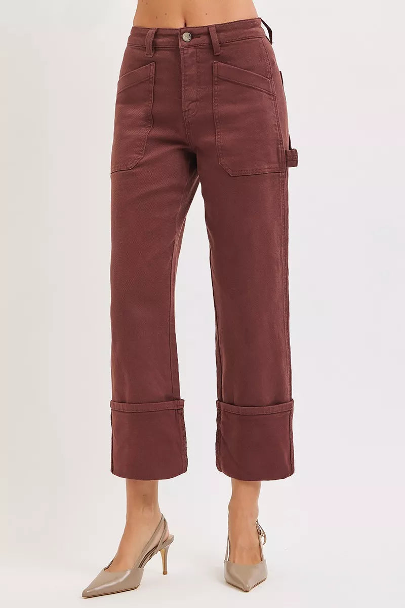 Burgundy pants worn by a person on a white background