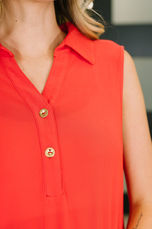 Red sleeveless top with gold buttons worn by a person