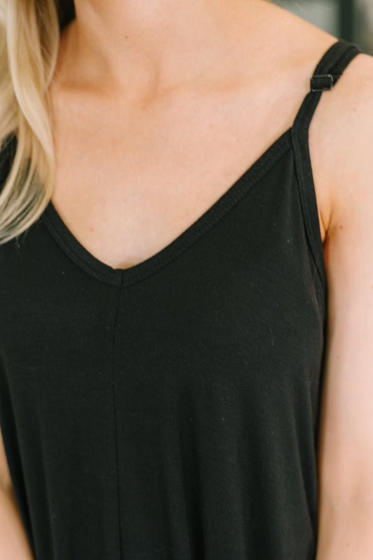Black tank top worn by a person with blonde hair, blurred background