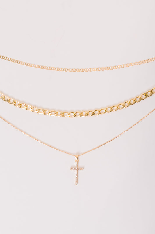 Gold necklace with a cross pendant on a white background