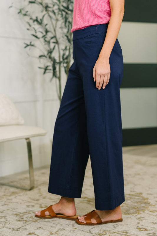 Person wearing navy wide-leg pants and a pink top indoors.