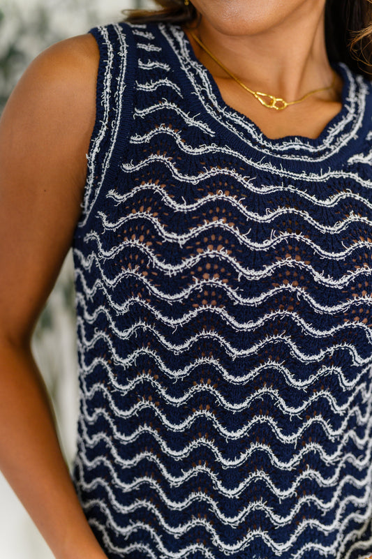 Navy blue sleeveless top with white wave pattern worn by a person.