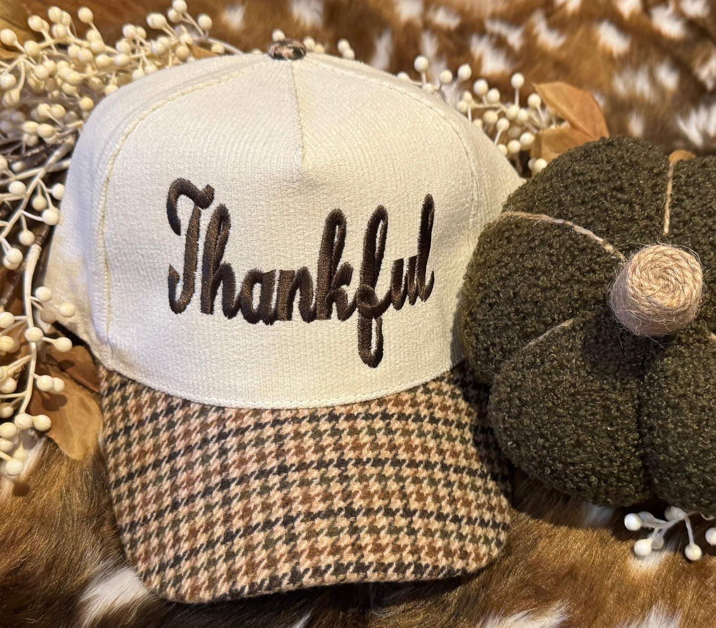 Trucker hat with 'Thankful' text on a decorative background with pumpkins and berries