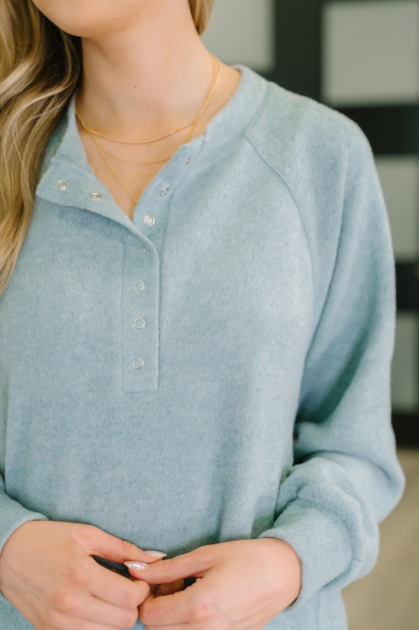 Light blue henley long-sleeve shirt worn by a person with a blurred background