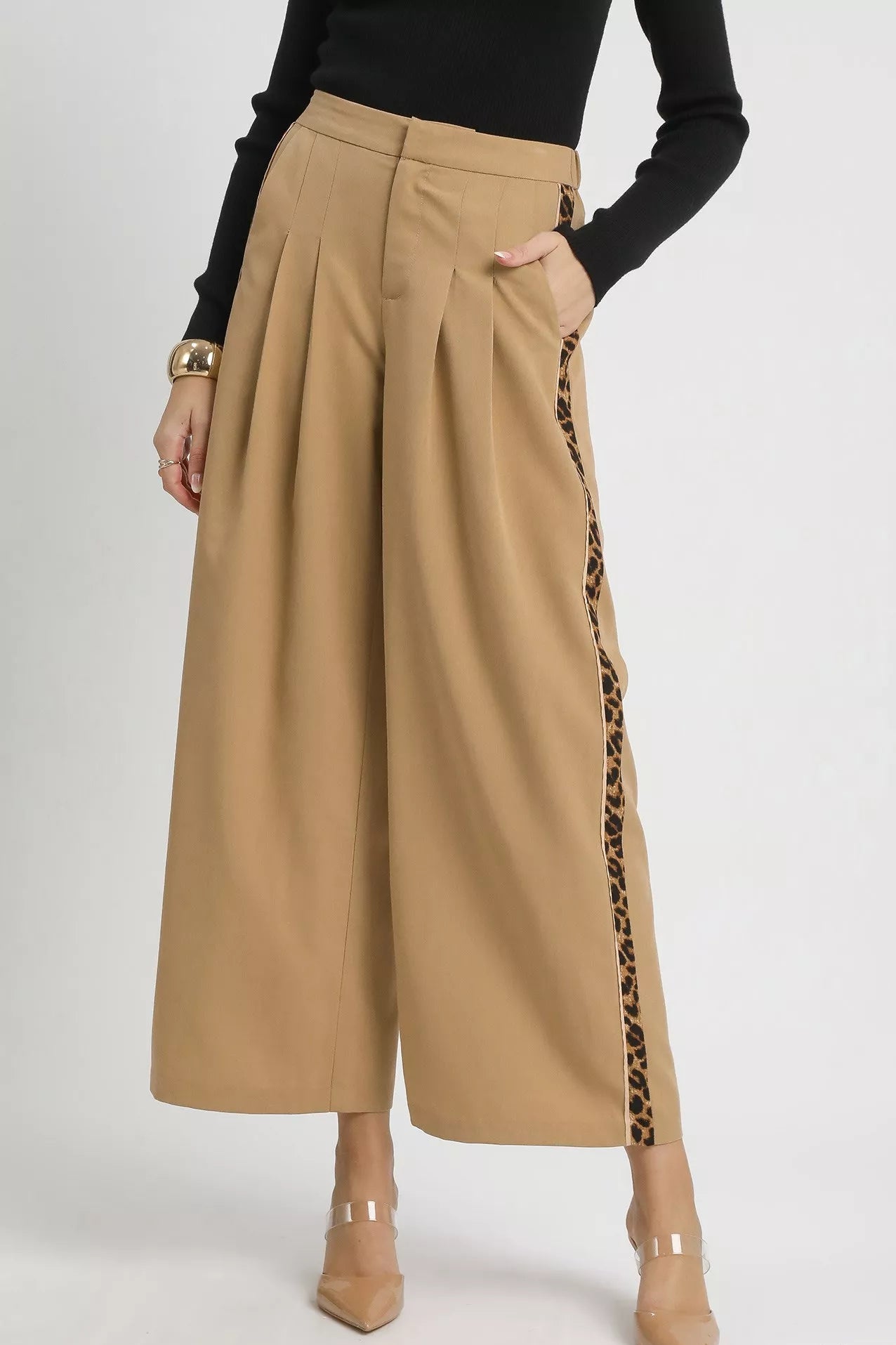 Beige wide-leg pants with leopard print side panels worn by a person on a white background