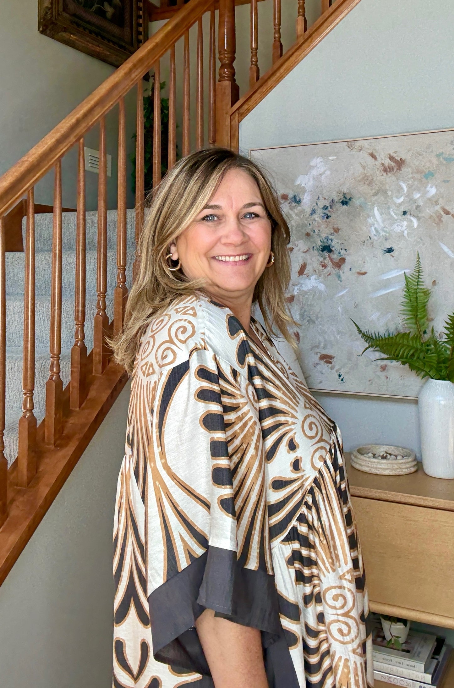 Woman standing in a home setting with a sideview of dress.