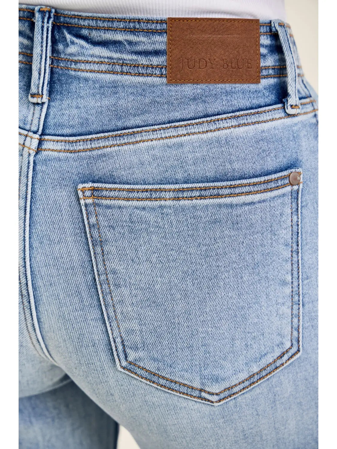 Close-up of blue jeans with a brown label on the back pocket.