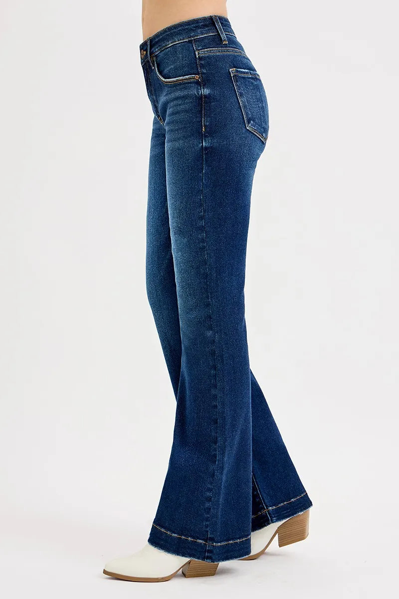 Blue flared jeans worn by a person on a white background