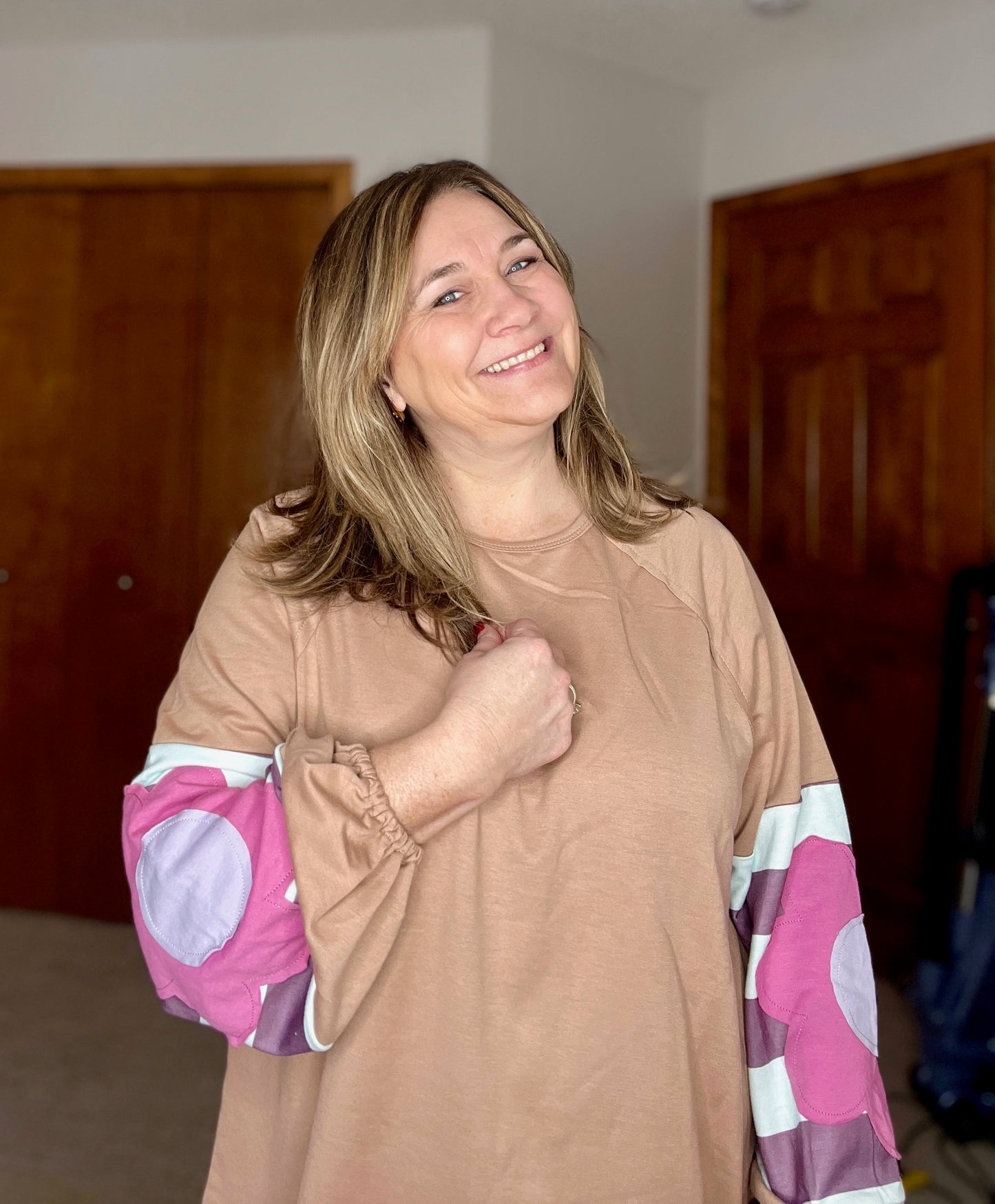 Woman wearing a boho floral top with colorful sleeves in an indoor setting