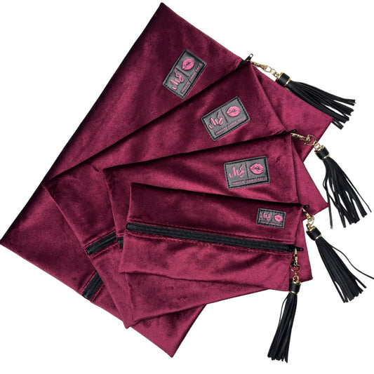 Set of burgundy pouches with tassels and visible brand logo on a white background
