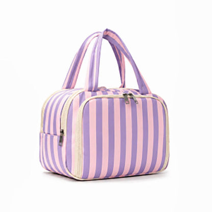 A striped zippered cosmetic bag with dual top handles, featuring vertical pink and purple stripes with cream-colored trim and silver zippers, shown on a plain white background.