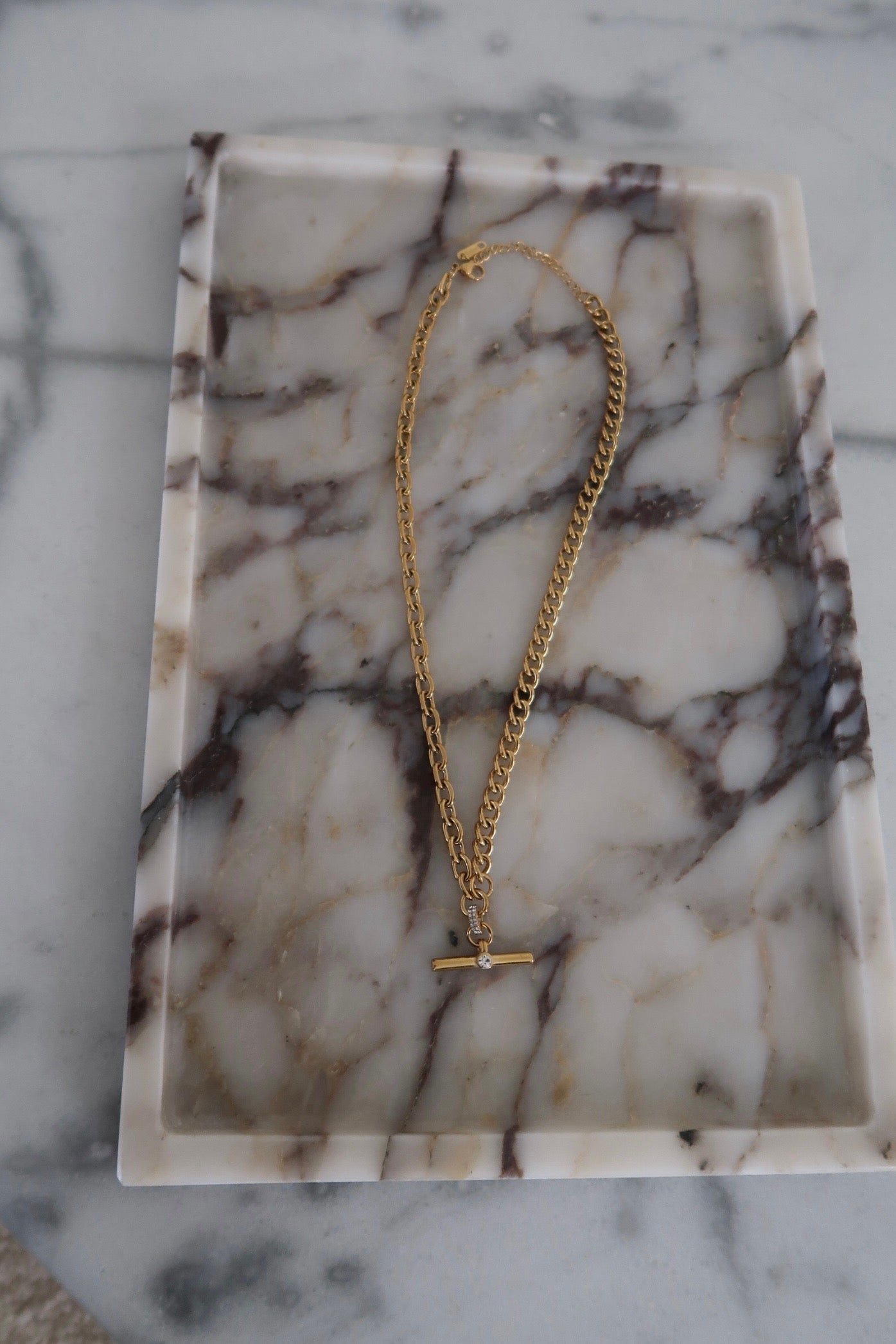 Gold chain necklace on a marble surface