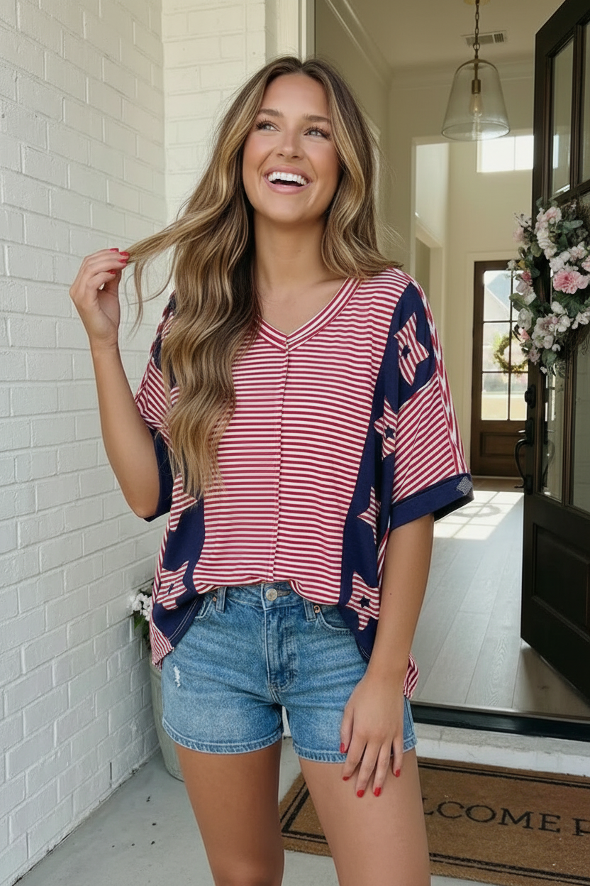 Woman wearing a red and blue striped shirt with denim shorts indoors.