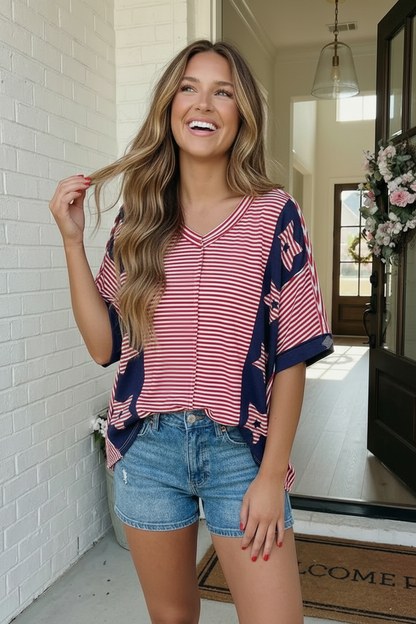 Woman wearing a red and blue striped shirt with denim shorts indoors.