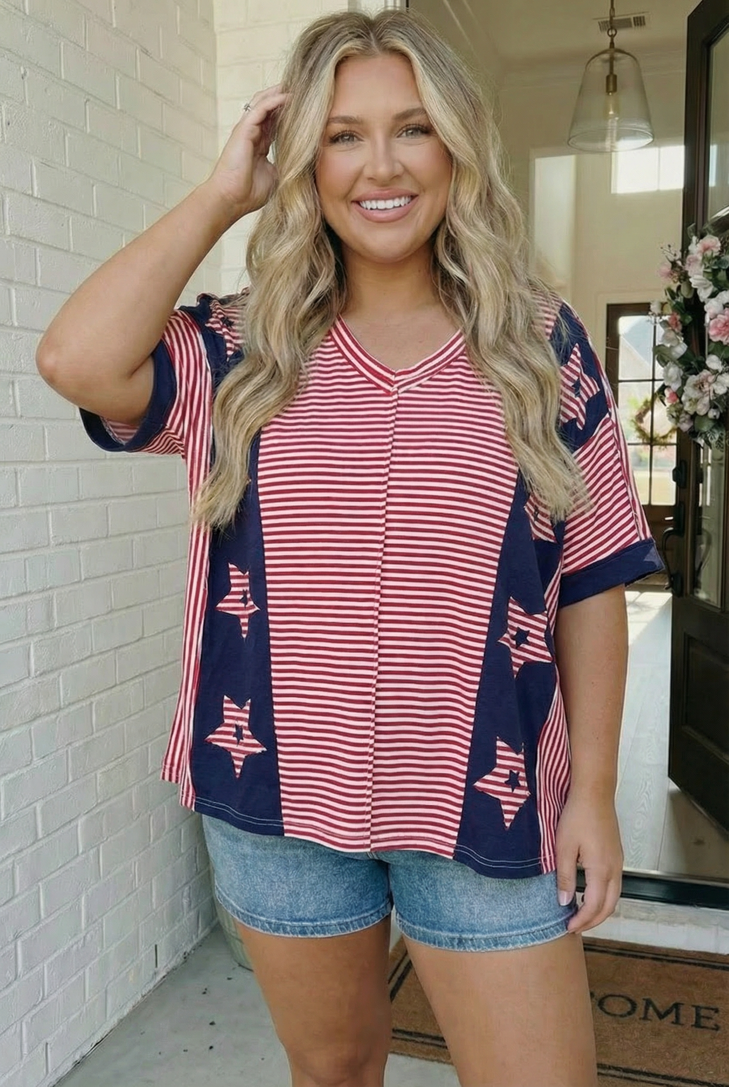 Woman wearing a red and blue striped top with star patterns in a casual setting.