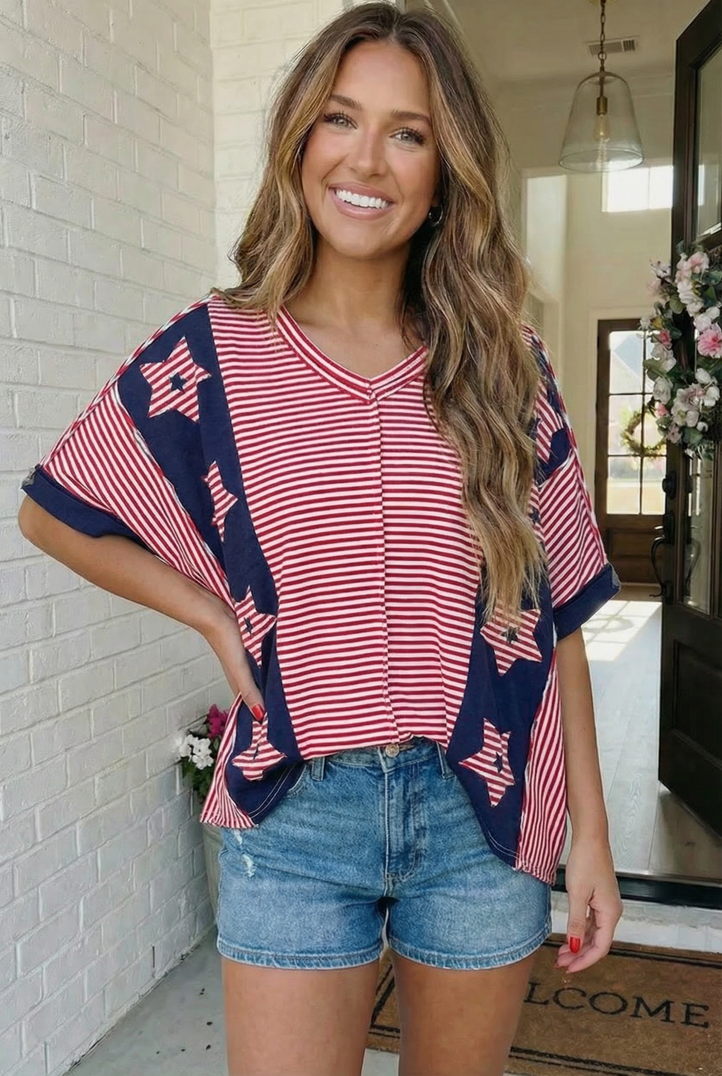 Woman wearing a red and blue striped top with star patterns in a home setting.