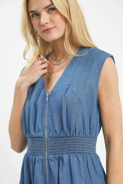 Woman wearing a blue denim dress with a white background