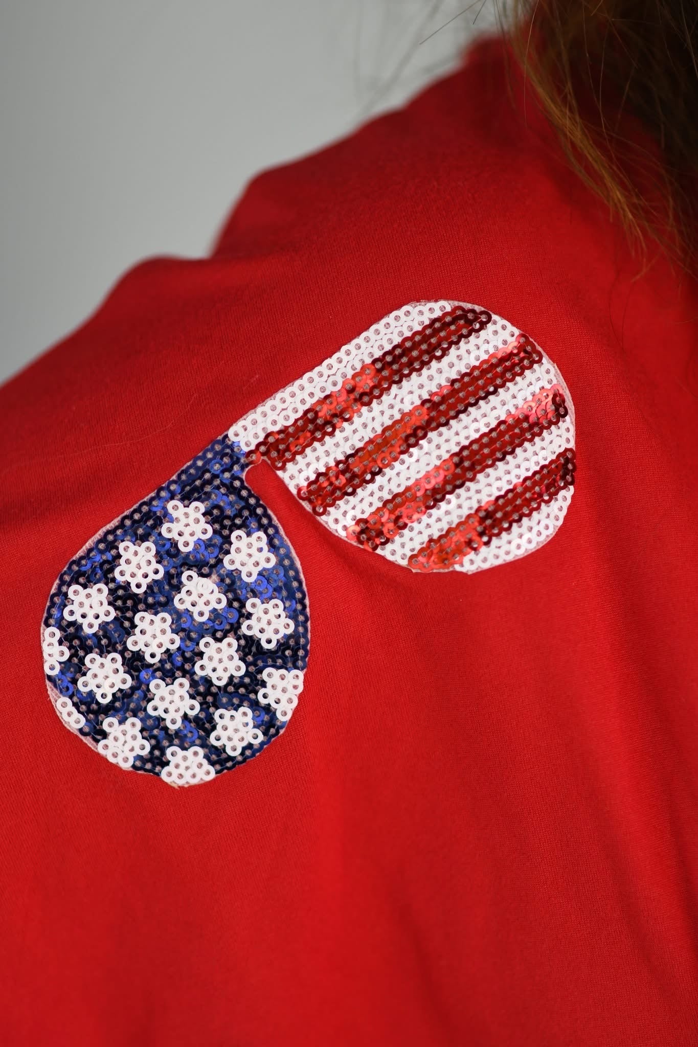 Red shirt with American flag sequin design on a plain background