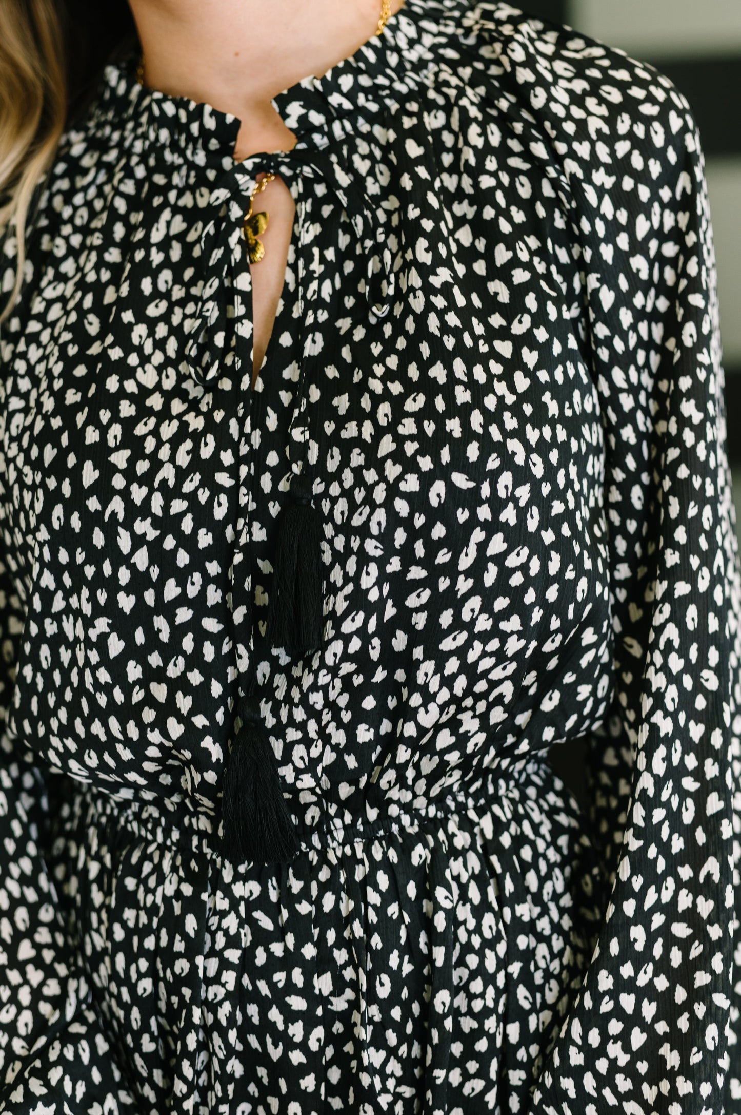 Black blouse with white pattern worn by a person