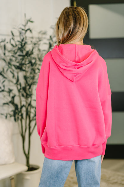 Person wearing a bright pink hoodie in an indoor setting