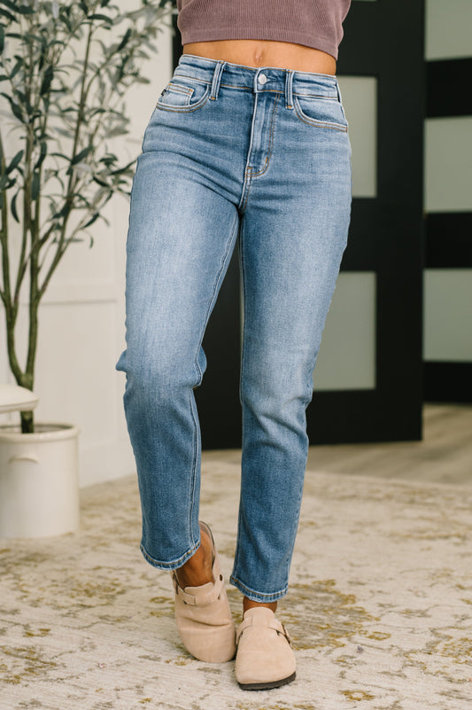 Person wearing blue jeans and beige shoes in a casual setting
