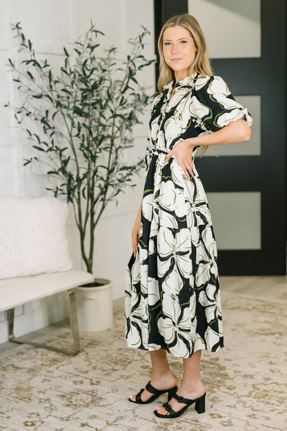 Woman wearing a black and white floral dress in an indoor setting.