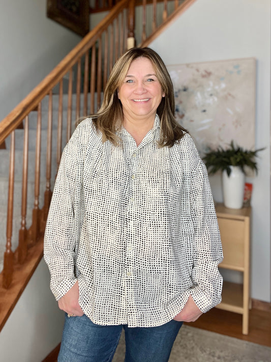 Woman standing in a home setting with a staircase in the background