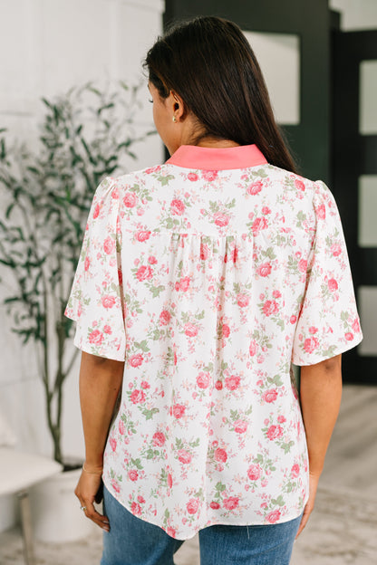 Woman wearing a floral blouse with a blurred indoor background