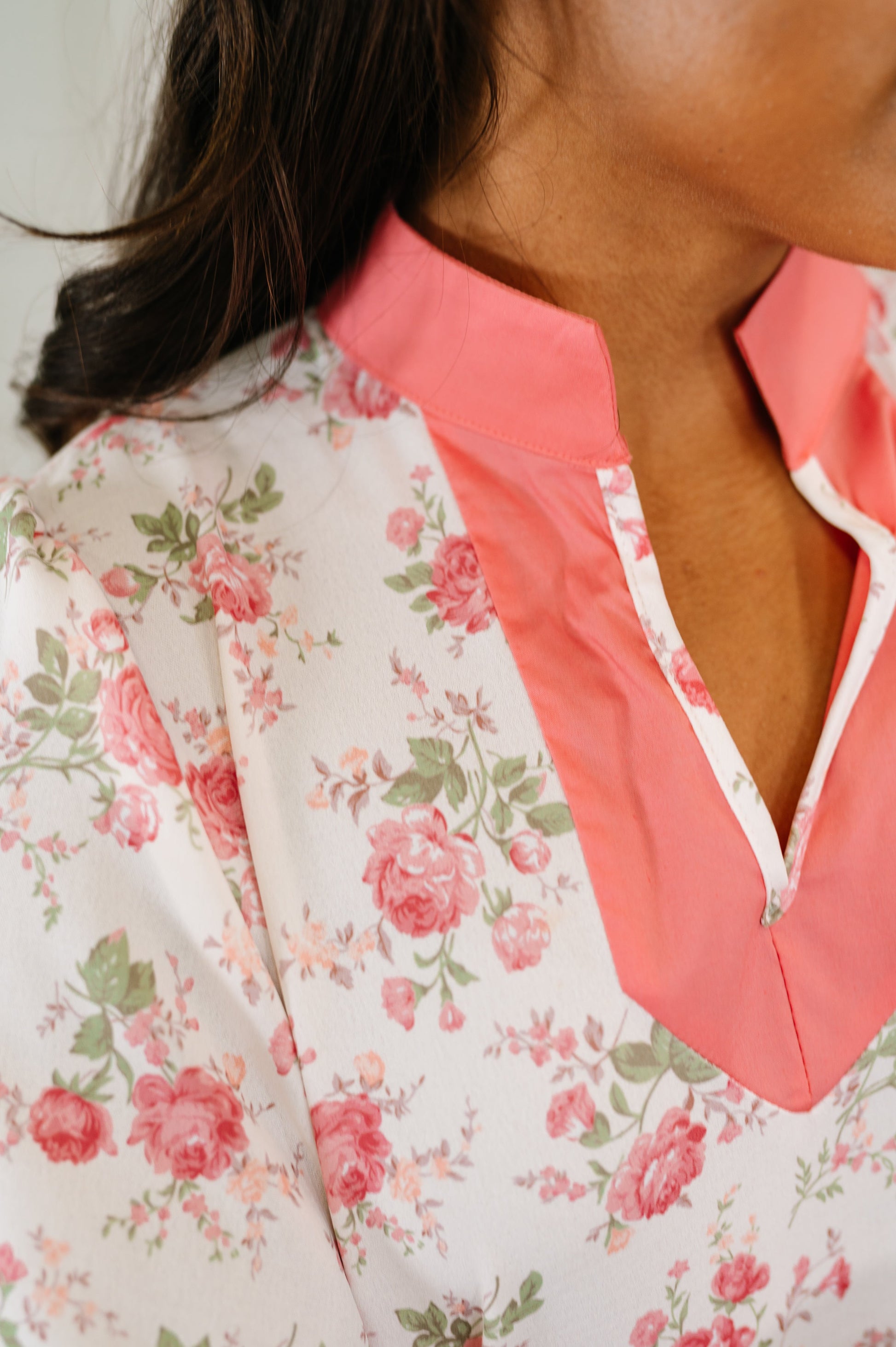 Close-up of a floral blouse with pink collar and neckline.