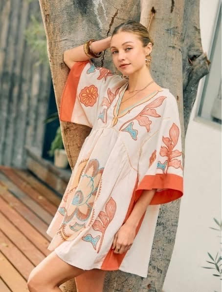 Woman wearing a floral kimono-style garment in an outdoor setting