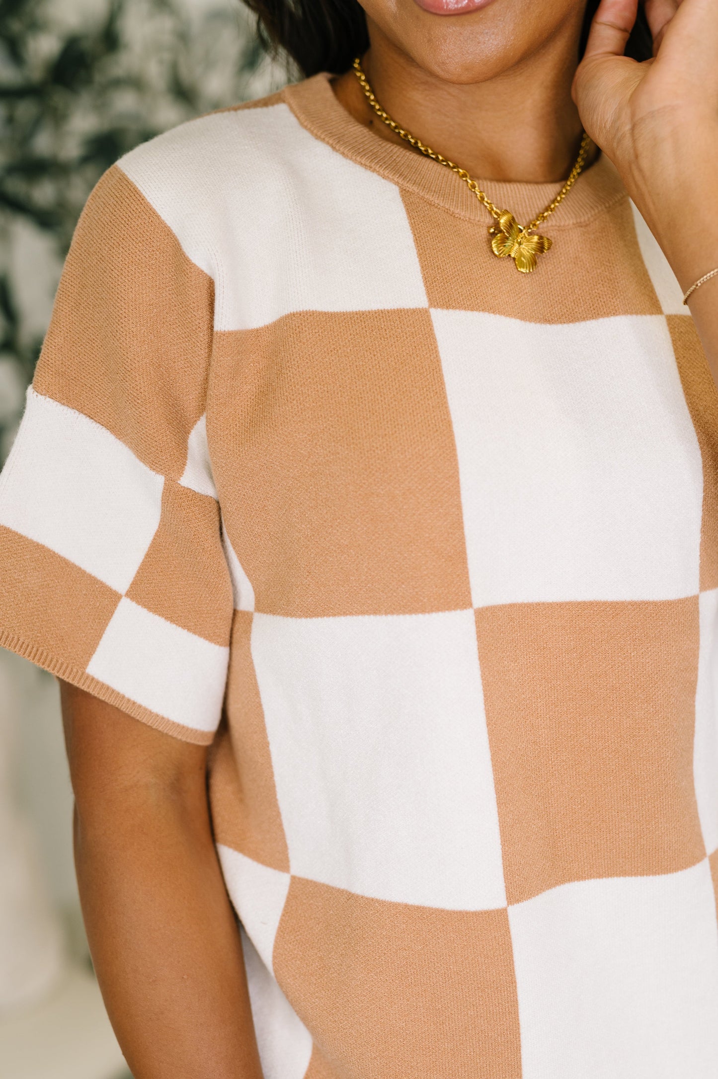 Person wearing a checkered shirt with a blurred background