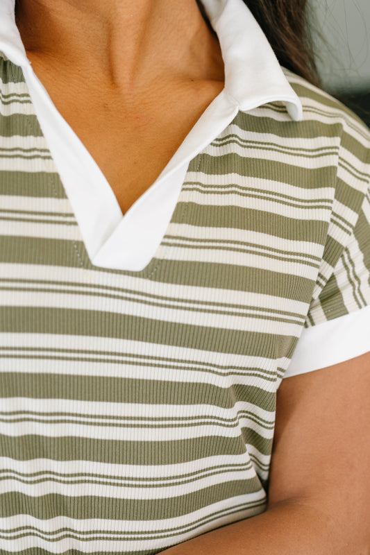 Close-up of a person wearing a green and white striped shirt with a white collar.