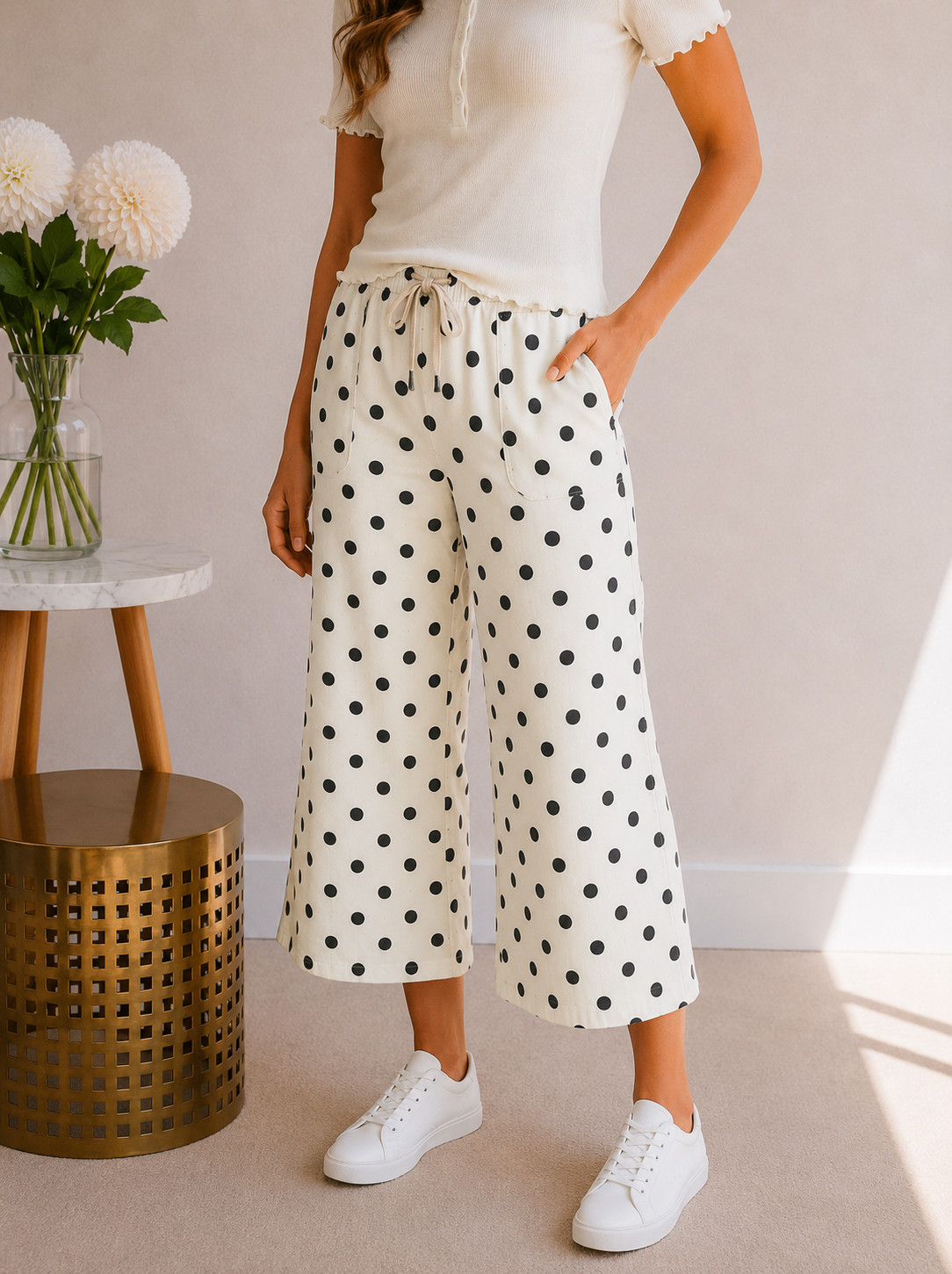 Person wearing polka dot pants with a neutral background