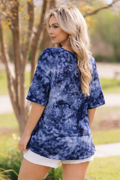 Woman wearing a blue tie-dye shirt in an outdoor setting