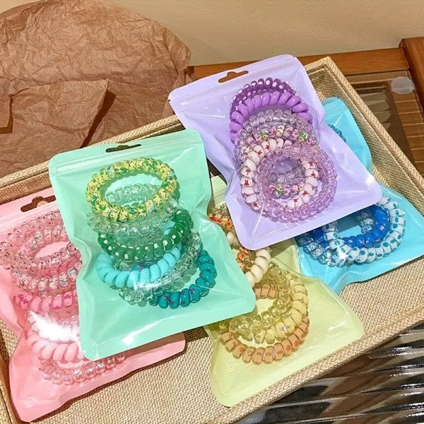 Colorful hair ties in packaging on a woven surface