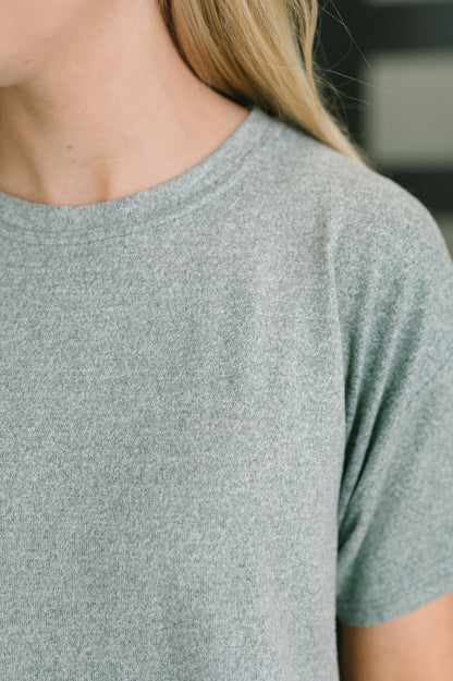 Close-up of a person wearing a short-sleeve crew-neck t-shirt in heather gray.