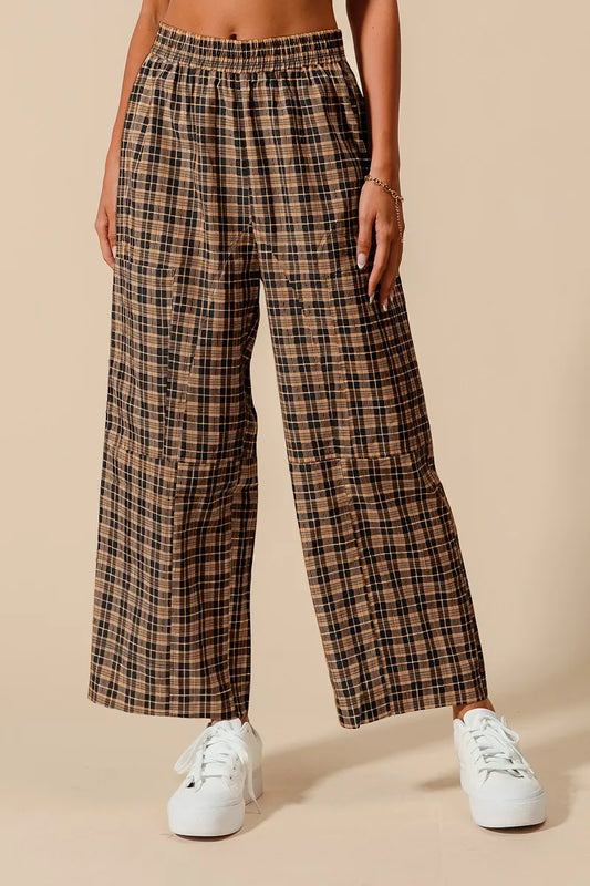 Plaid pants worn by a person on a beige background