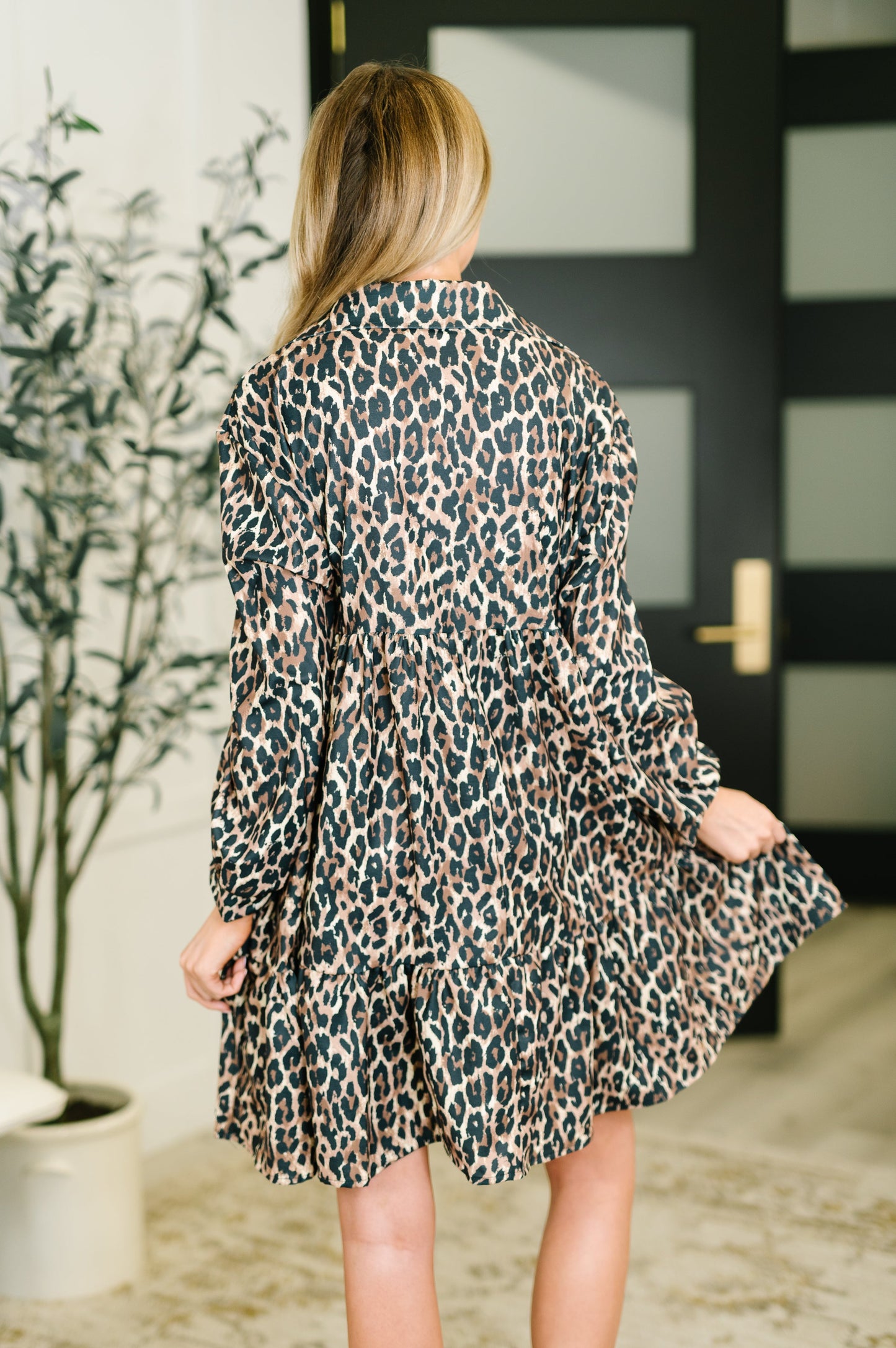 Person wearing a leopard print dress in an indoor setting