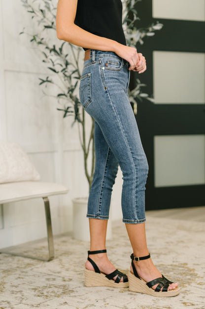 Person wearing blue jeans and black sandals in a casual setting