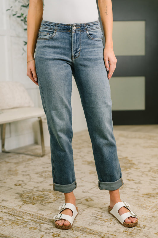Person wearing blue jeans and white sandals in a casual setting