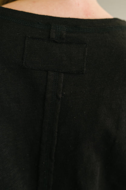 Close-up of black pants with a pocket detail.