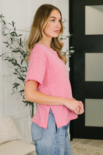 Woman wearing a pink top and blue jeans in an indoor setting