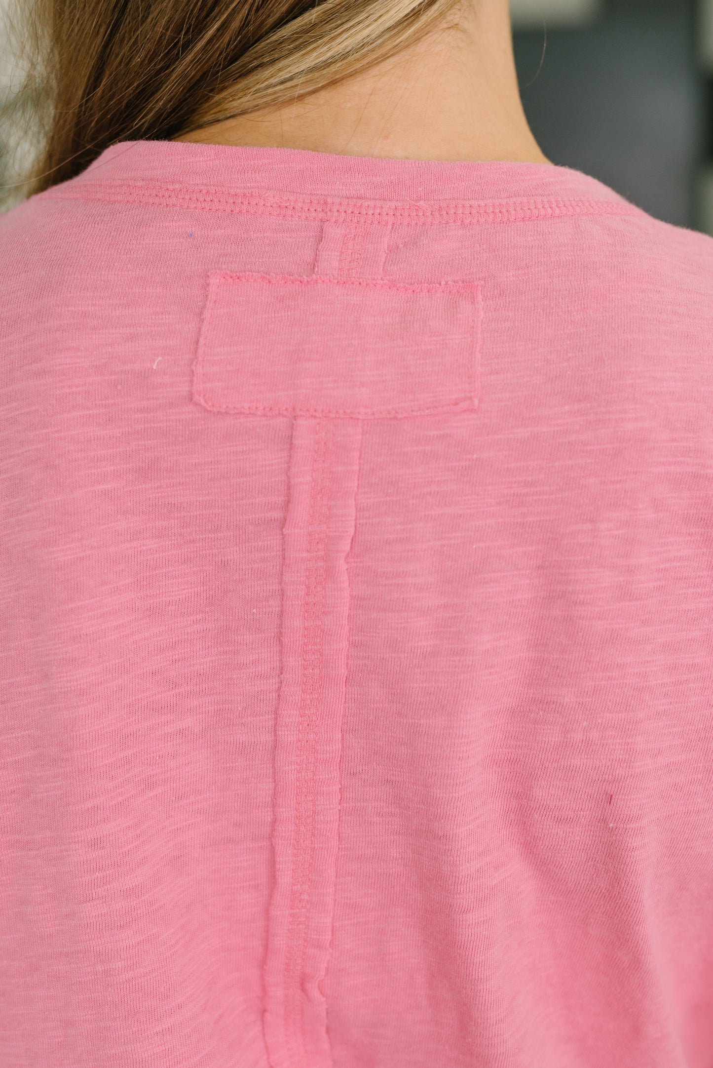 Close-up of a pink shirt with a pocket on a blurred background