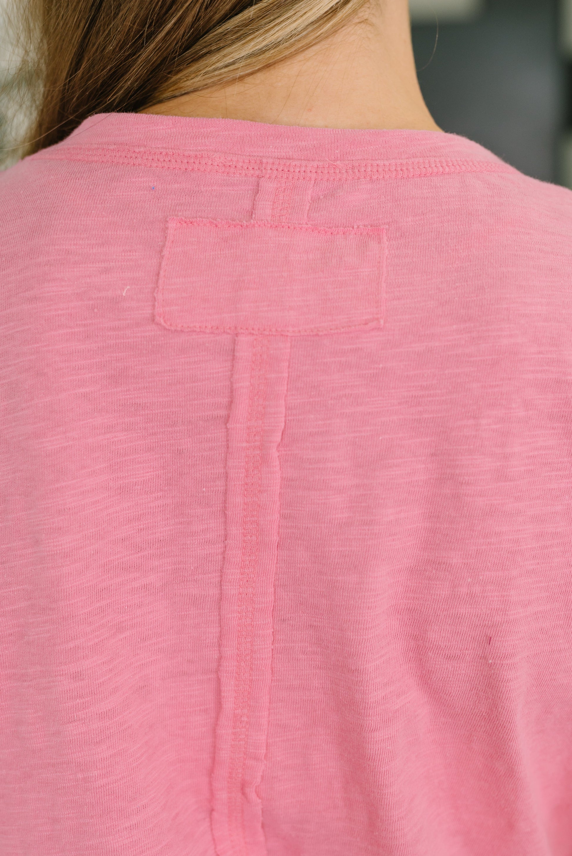 Close-up of a pink shirt with a pocket on a blurred background