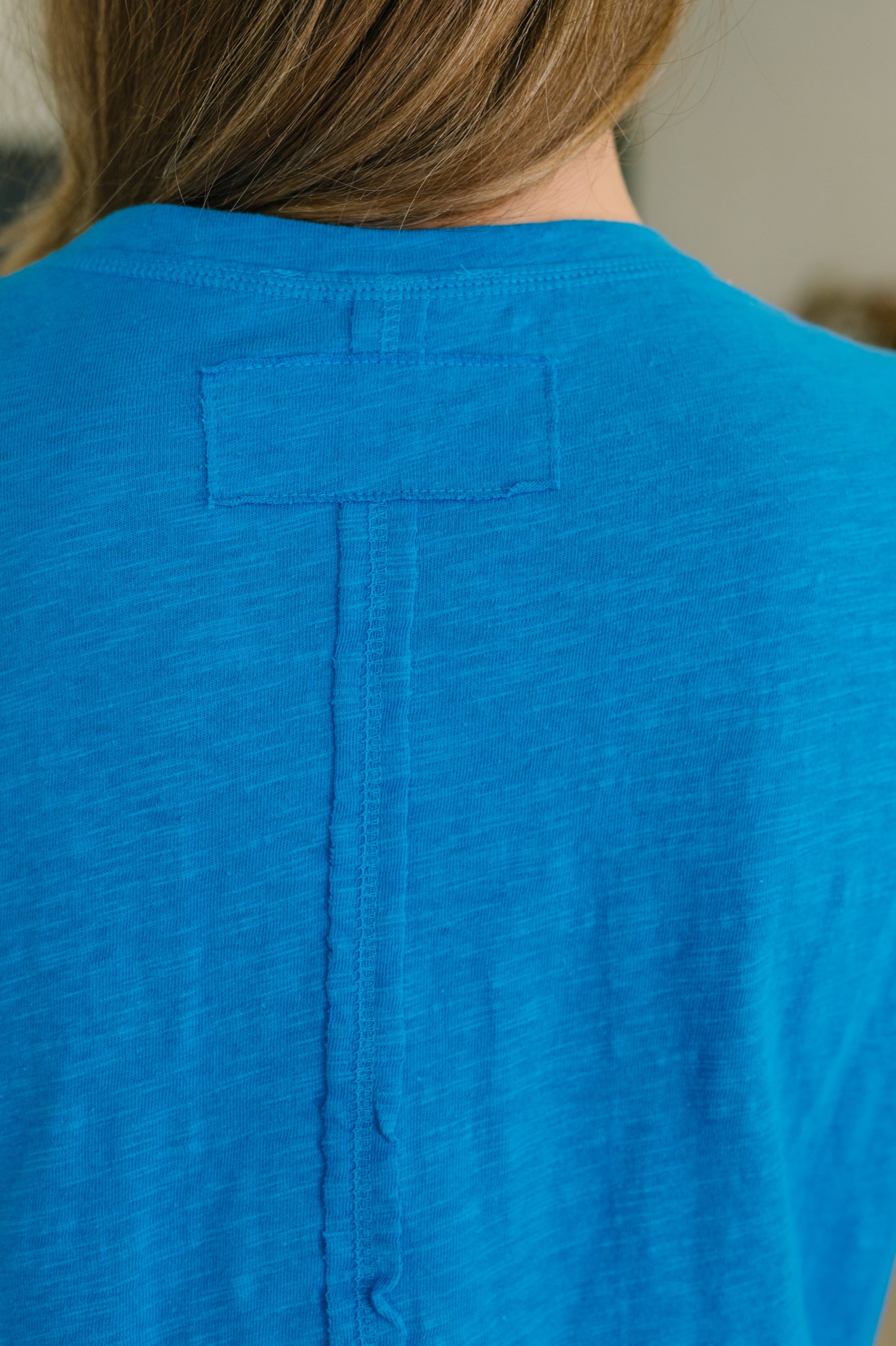 Close-up of a blue shirt with a button on the back