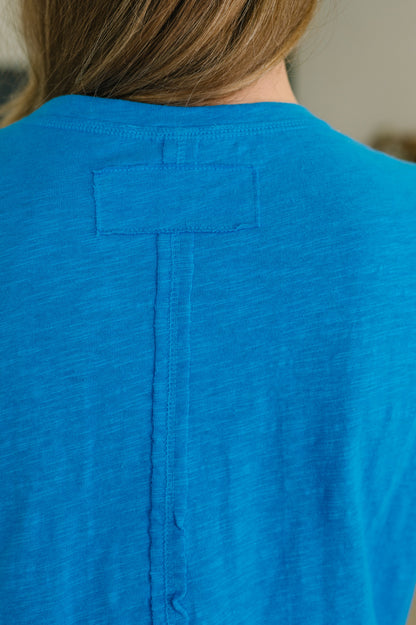 Close-up of a blue shirt with a button on the back