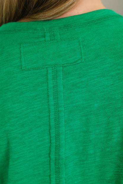 Green shirt with a pocket on a plain background